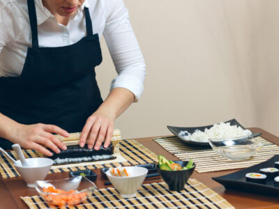 Portrait of woman chef rolling up a japanese sushi