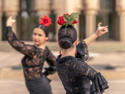 Medium shot of flamenco ballerina on her back with bun hair and a rose on her head