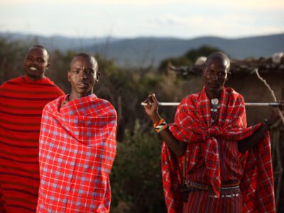 MASAI MARA, KENYA - Jan 01, 2013: A shallow focus shot of three African males with blankets wrapped around them