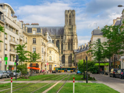Tram on the streets and Architecture of Reims a city in the Champagne-Ardenne region of France.