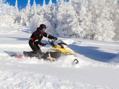 Athlete on a snowmobile moving in the winter forest in the mountains of the Southern Urals.