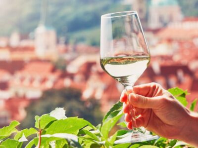 Hand of the man holding glass of white wine. Relaxation in Prague, Czech Republic.