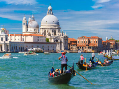 Picturesque view of Gondolas on Canal Grande with Basilica di Santa Maria della Salute in the background, Venice, Italy. Selective focus on Gondolier