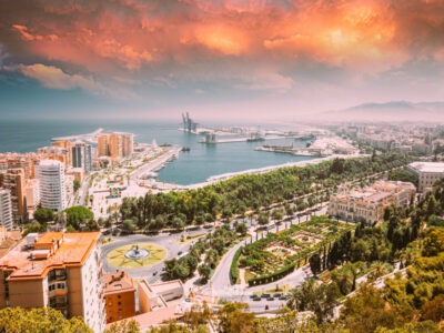 Malaga, Spain. Cityscape Elevated View Of Malaga In Sunny Summer Evening. Altered Sunset Sky.