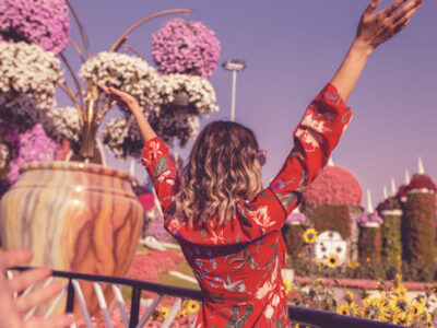 rear-view-young-woman-standing-ornamental-garden-against-sky