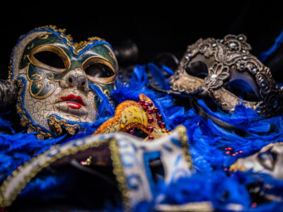 Venetian carnival mask on blue feather background