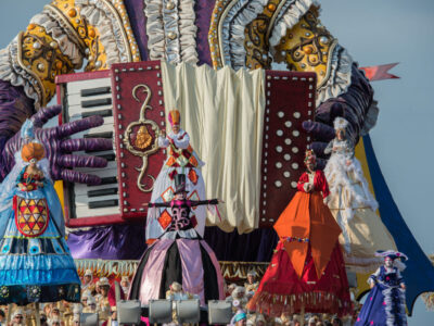 VIAREGGIO, ITALY - FEBRUARY 17, 2013 - Carnival Show parade on town street with traditional Burlamacco Pulcinella style mask and wagon papier mache stone faced parade