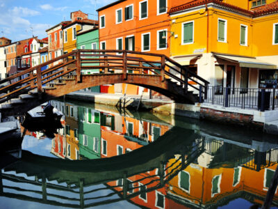 Venice, Burano, bridge over the canal and colorful houses, Italy