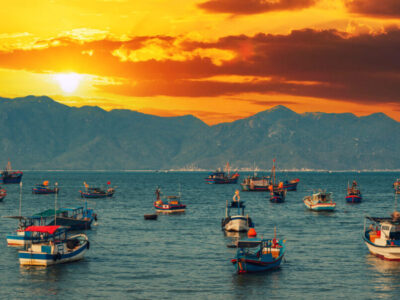 Vietnamese traditional fishing boats in the sea at marina at sunset in summer